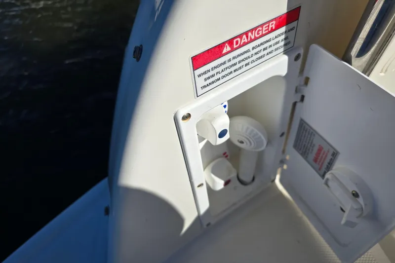 Slide: The Image of 2007 Monterey 250 Cruiser boat control panel with warning label and open compartment. - 13