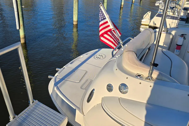 Slide: The Image of 2007 Monterey 250 Cruiser boat docked with American flag, sunny day reflection on water. - 26