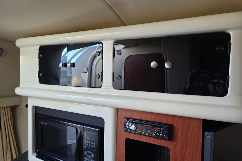 Slide: The Image of Interior of a 2007 Monterey 250 Cruiser featuring cabinets, microwave, and stereo system. - 30