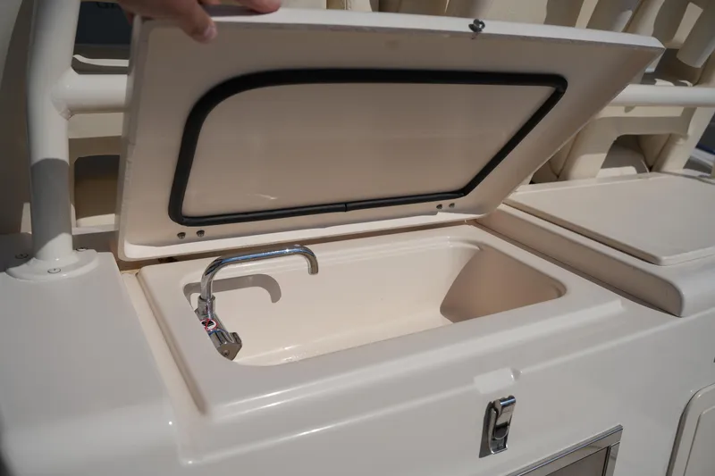 Slide: The Image of 2021 Grady-White Canyon 326 boat sink with open lid and faucet. - 13