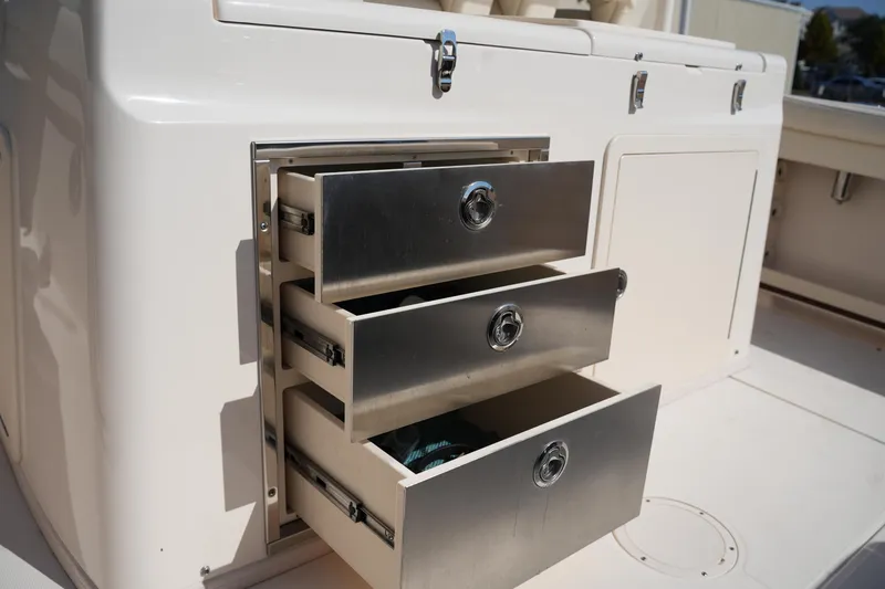 Slide: The Image of 2021 Grady-White Canyon 326 boat with open stainless steel storage drawers. - 14