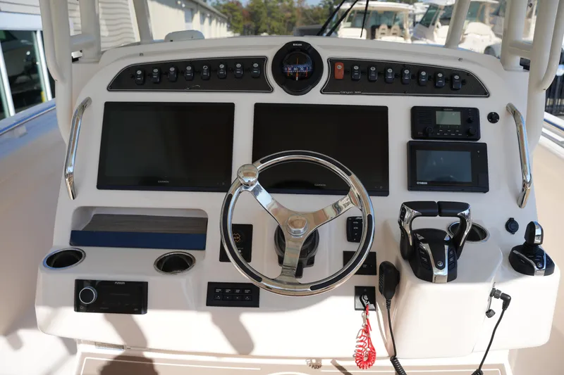 Slide: The Image of Control panel of 2021 Grady-White Canyon 326 boat with steering wheel and navigation screens. - 19