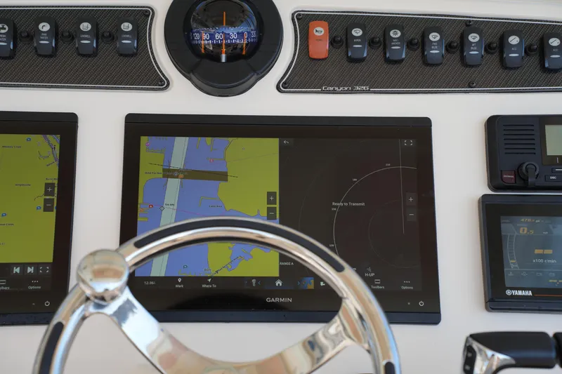 Slide: The Image of 2021 Grady-White Canyon 326 dashboard with Garmin navigation and control panels. - 21