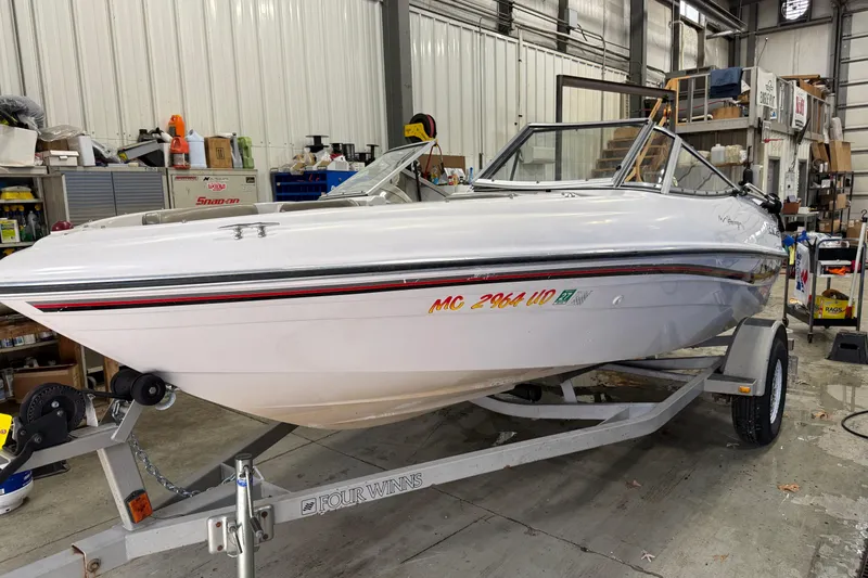 The Image of 1999 Four Winns 170 Horizon LE boat on trailer in a garage setting. - 0