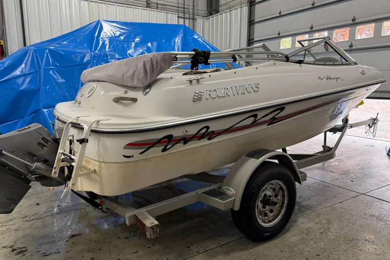Slide: The Image of 1999 Four Winns 170 Horizon LE boat on trailer in garage setting. - 4