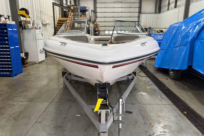 Slide: The Image of 1999 Four Winns 170 Horizon LE boat on trailer in garage setting. - 5