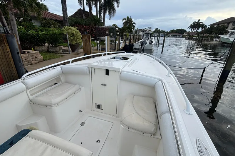 Slide: The Image of 2004 Marlago 35fs boat docked by a waterfront, featuring spacious seating and sleek design. - 12