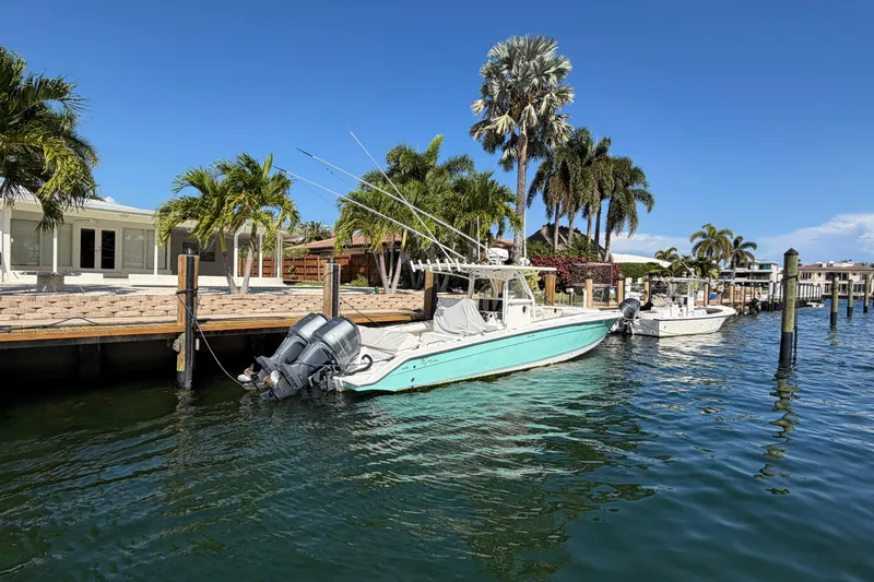 Slide: The Image of 2004 Marlago 35fs boat docked by palm trees under clear blue sky. - 3