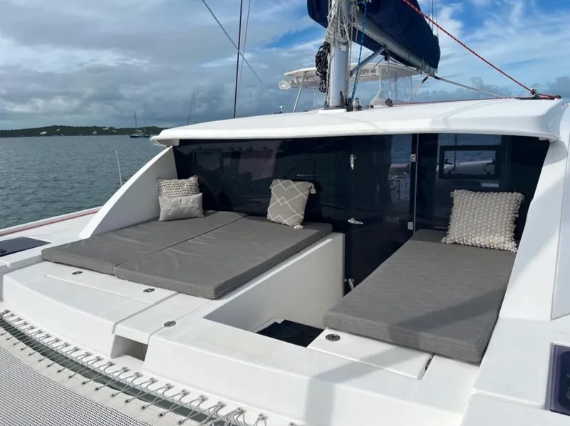 Slide: The Image of 2018 Leopard 40 catamaran with cushioned deck seating, anchored on a calm sea. - 1