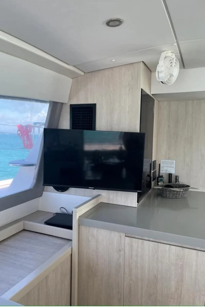 Slide: The Image of Modern interior of a 2018 Leopard 40 catamaran with a flat-screen TV and light wood finishes. - 21