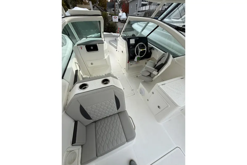 Slide: The Image of 2026 Pursuit DC 266 Dual Console boat interior with modern seating and steering wheel. - 7
