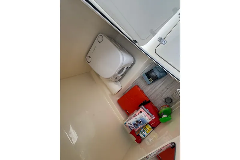 Slide: The Image of Interior of 2024 Scout 215 Dorado boat with portable toilet and storage items. - 11