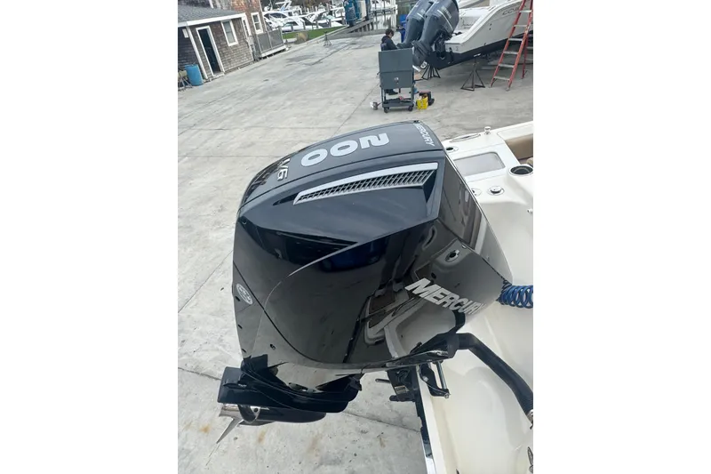 Slide: The Image of 2024 Scout 215 Dorado with Mercury outboard engine, docked at a marina. - 12