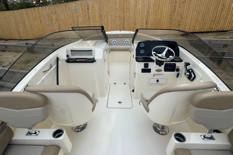 Slide: The Image of 2024 Scout 215 Dorado boat interior with steering wheel and seating. - 4
