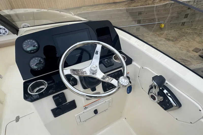 Slide: The Image of 2024 Scout 215 Dorado boat dashboard with steering wheel and control panel. - 5