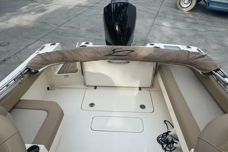 Slide: The Image of 2024 Scout 215 Dorado boat interior with beige seating and covered engine. - 6