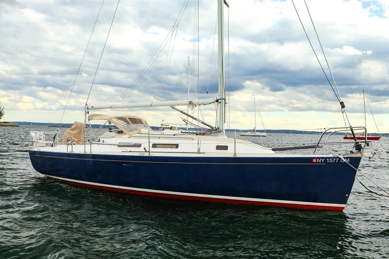 The Image of 1999 J Boats J/32 sailboat on water under cloudy sky. - 0