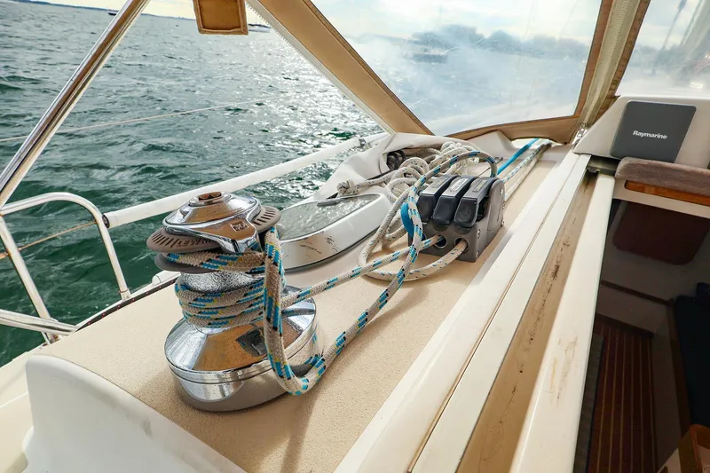 Slide: The Image of 1999 J Boats J/32 sailboat deck with winch and ropes, sailing on open water. - 14