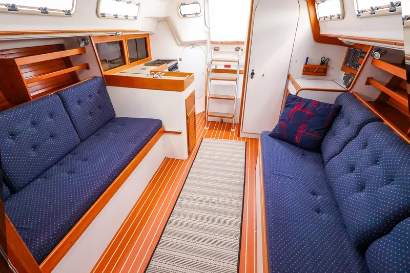 Slide: The Image of Interior of a 1999 J Boats J/32 sailboat with blue cushioned seating. - 20