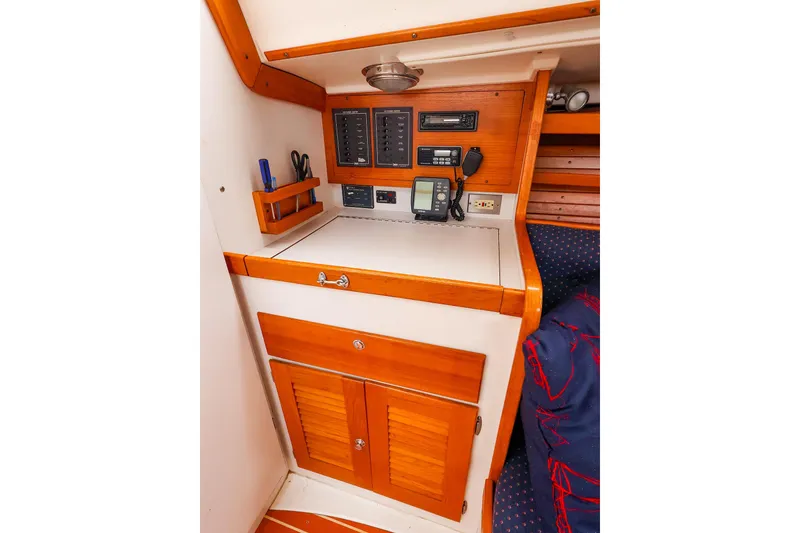 Slide: The Image of 1999 J Boats J/32 navigation station with control panel and storage cabinets. - 25