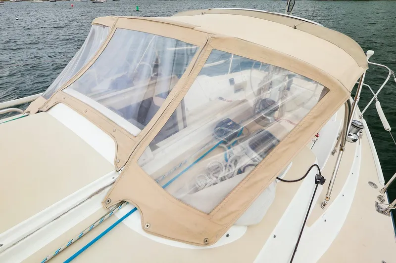 Slide: The Image of 1999 J Boats J/32 sailboat with beige canopy and clear windows on the water. - 8