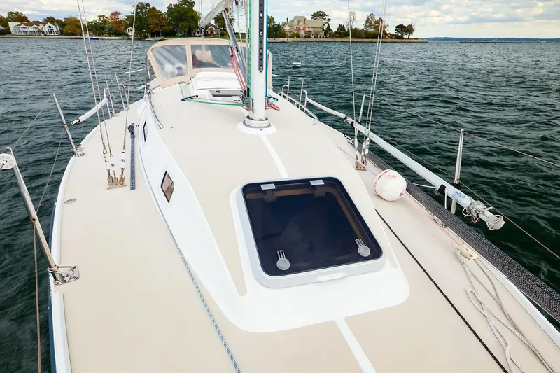 Slide: The Image of 1999 J Boats J/32 sailboat deck view on calm water, showcasing sleek design. - 9