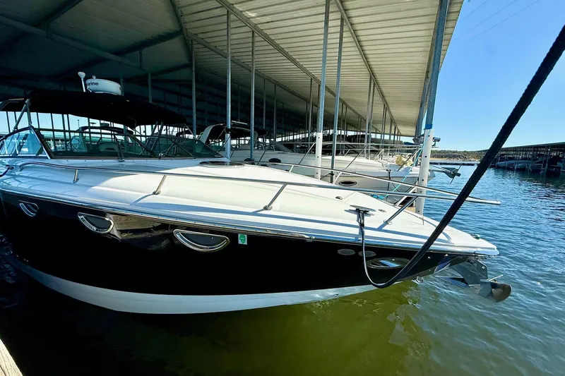 Slide: The Image of 2007 Cobalt 323 boat docked in a marina under a covered structure. - 10