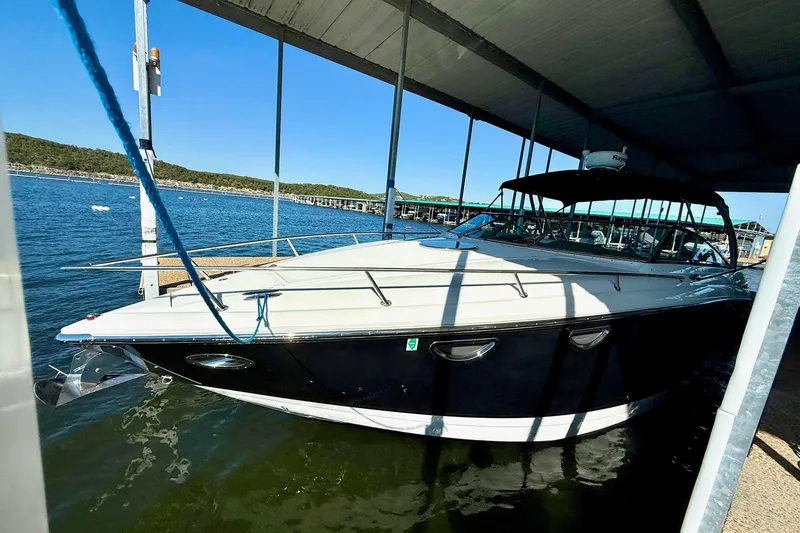 Slide: The Image of 2007 Cobalt 323 boat docked under a canopy on a sunny day. - 12