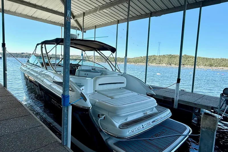 Slide: The Image of 2007 Cobalt 323 boat docked under a canopy on a serene lake. - 13