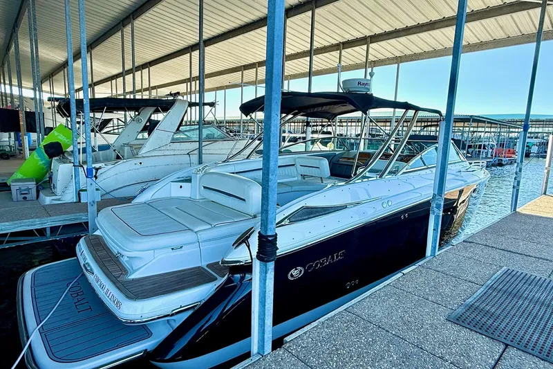 Slide: The Image of 2007 Cobalt 323 boat docked in a marina under a covered slip. - 14