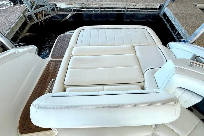 Slide: The Image of Luxurious white seating on a 2007 Cobalt 323 boat, docked with wooden accents. - 23
