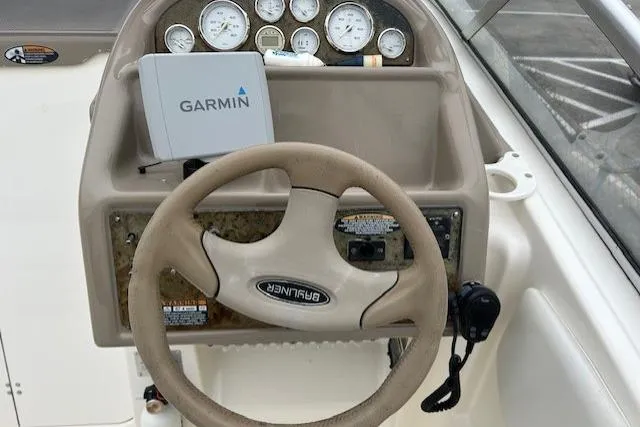 Slide: The Image of 2003 Bayliner 285 boat dashboard with Garmin GPS and steering wheel. - 11
