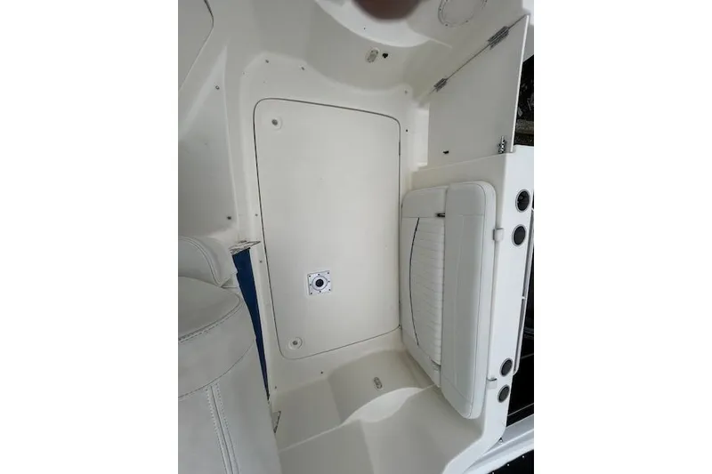 Slide: The Image of 2003 Bayliner 285 boat interior, featuring white seating and storage compartments. - 12