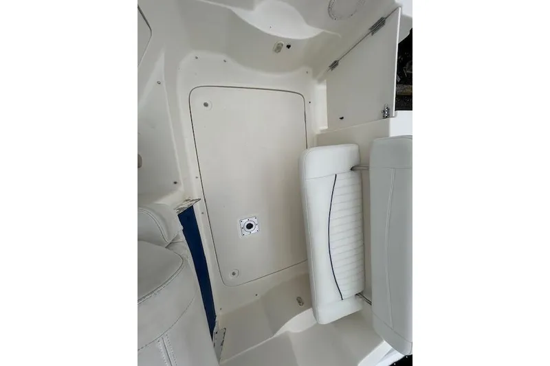 Slide: The Image of 2003 Bayliner 285 boat interior with white seating and storage compartment. - 13