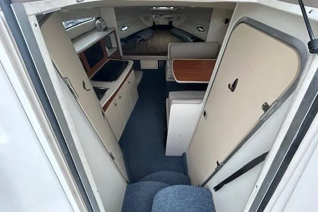 Slide: The Image of 2003 Bayliner 285 cabin interior with kitchenette, seating, and sleeping area. - 15