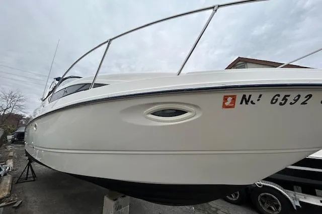 Slide: The Image of 2003 Bayliner 285 boat on dry dock, side view with registration number visible. - 2