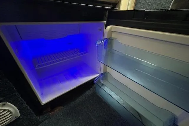 Slide: The Image of Open refrigerator with blue interior light in a 2003 Bayliner 285 boat. - 21