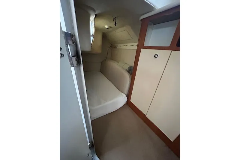 Slide: The Image of 2003 Bayliner 285 cabin interior with bed and storage cabinets. - 22