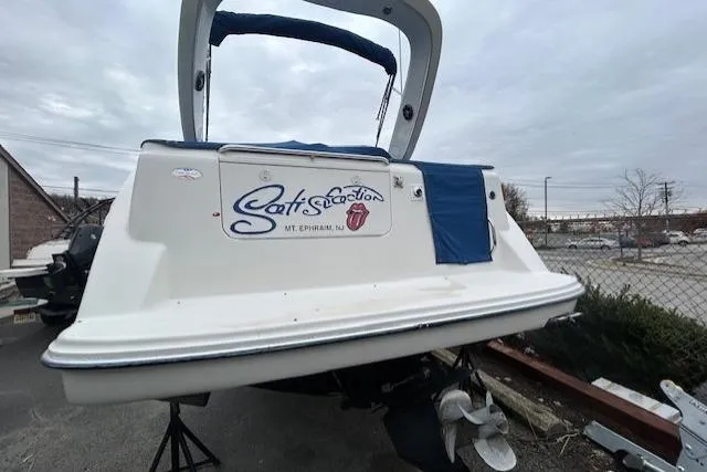 Slide: The Image of 2003 Bayliner 285 boat with custom graphics, docked outdoors on a cloudy day. - 3