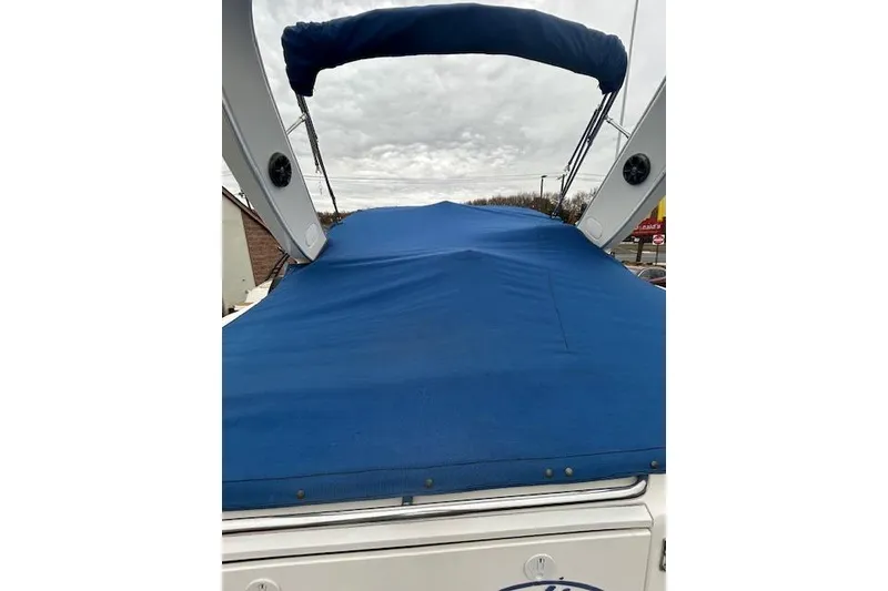 Slide: The Image of 2003 Bayliner 285 boat with blue cover and canopy, docked outdoors. - 4