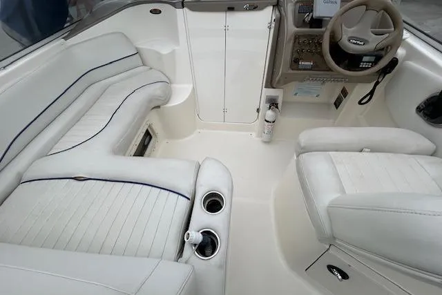Slide: The Image of 2003 Bayliner 285 boat interior with white seating and steering console. - 9