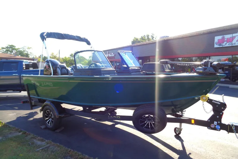 Slide: The Image of 2026 Lund 1800 Explorer Sport boat on trailer, parked outdoors in sunlight. - 3