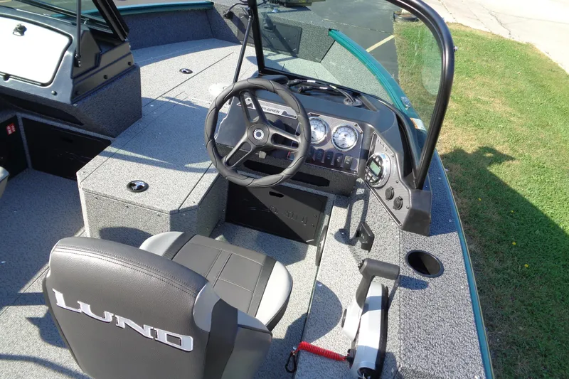 Slide: The Image of 2026 Lund 1800 Explorer Sport boat interior with steering wheel and dashboard controls. - 7