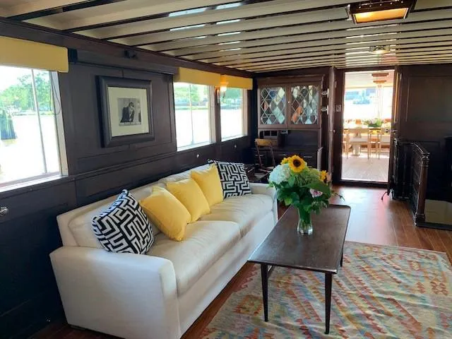 Slide: The Image of Interior of 1947 Trumpy Raised Pilot House with cozy seating and floral decor. - 7