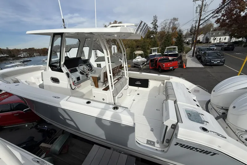 Slide: The Image of 2026 Pursuit S 288 Sport boat with sleek design, docked near waterfront. - 4