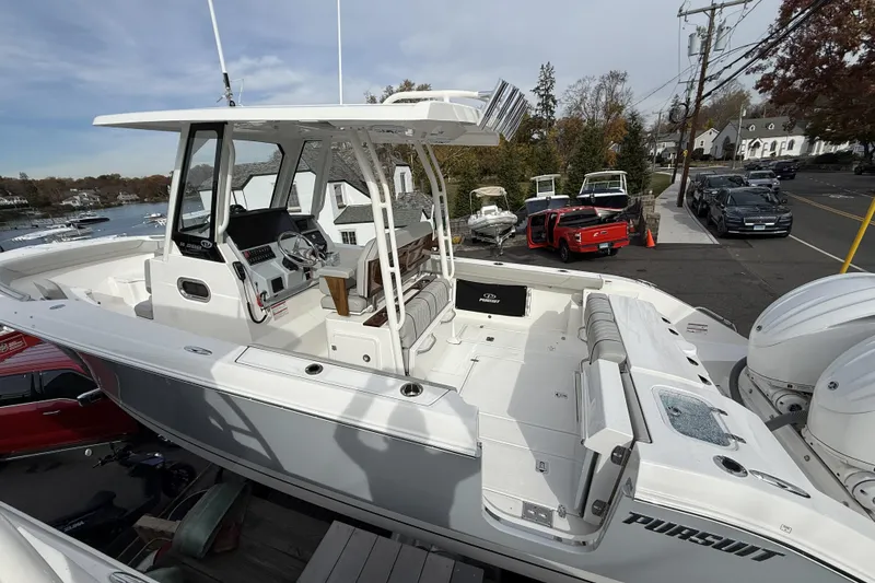 Slide: The Image of 2026 Pursuit S 288 Sport boat with spacious deck and modern controls, docked near waterfront. - 5