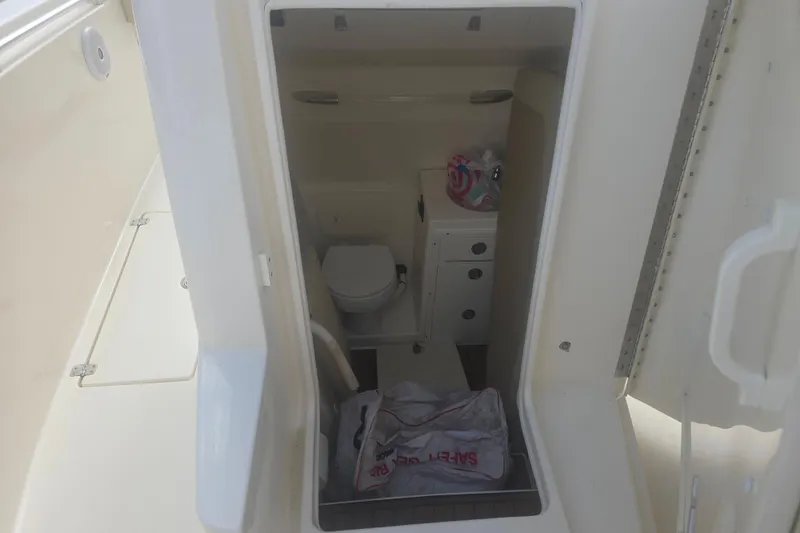 Slide: The Image of 2017 Cobia 296 Center Console boat interior with toilet and storage area. - 17