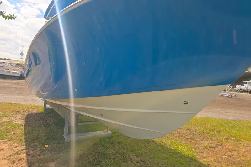 Slide: The Image of 2017 Cobia 296 Center Console boat on display, blue hull, sunny day. - 2