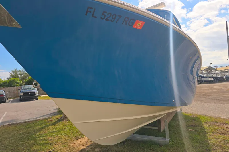 Slide: The Image of 2017 Cobia 296 Center Console boat on trailer, blue hull, sunny day. - 3