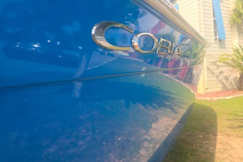 Slide: The Image of 2017 Cobia 296 Center Console boat with shiny blue hull and logo. - 5